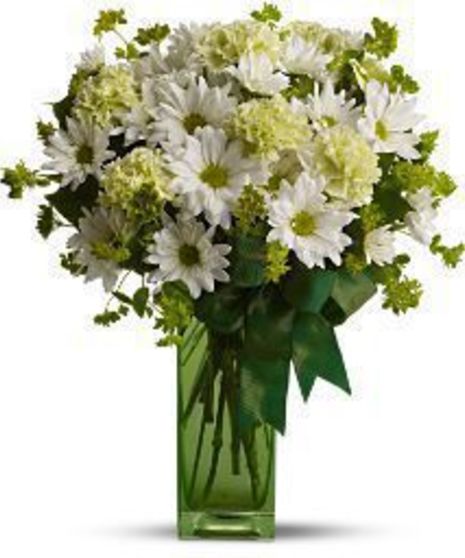 Daisies and green flowers in a green cube vase.