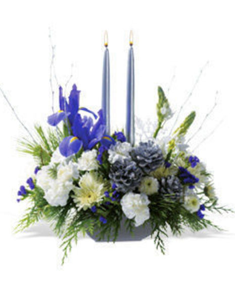 Hanukkah centerpiece with blue and white flowers and blue taper candles