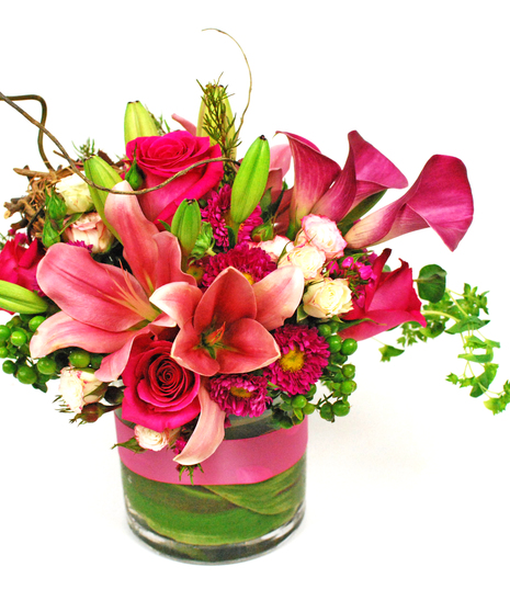 Asiatic lilies, calla lilies, roses, jap aster and assorted greenery with a bird's nest decoration.