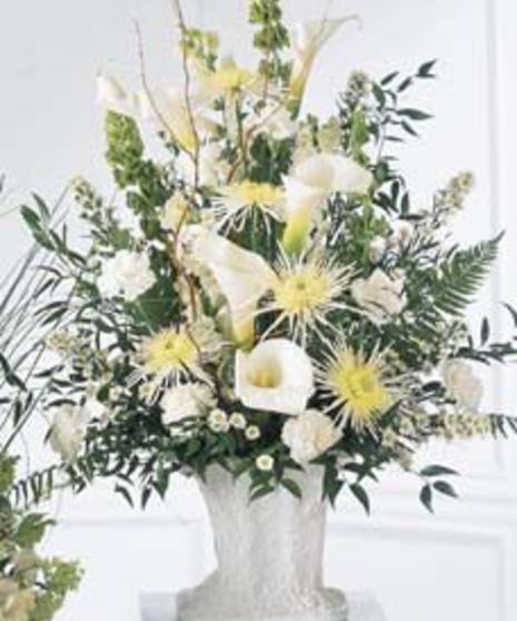 White calla lilies and spider chrysanthemums in a traditional sympathy arrangement. 