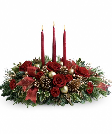 Christmas centerpiece of red flowers, greenery, pine cones, ornaments, ribbon and candles.