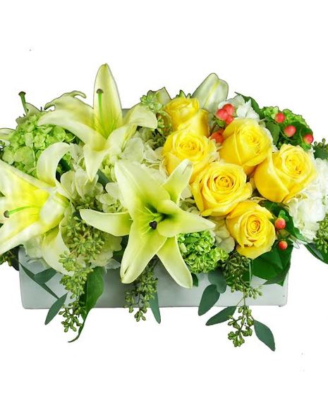 Centrpiece with bright yellow, green and white flowers and greenery