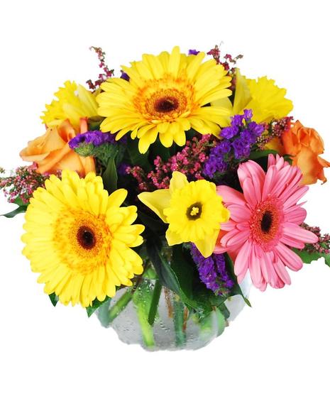 Bright yellow, pink and purple flowers in a glass bowl vase.