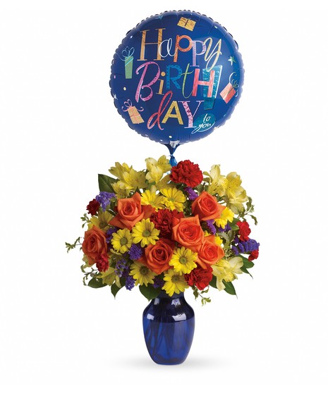 Colorful birthday bouquet of flowers inside a blue vase with a happy birthday balloon