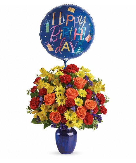 Colorful birthday bouquet of flowers inside a blue vase with a happy birthday balloon