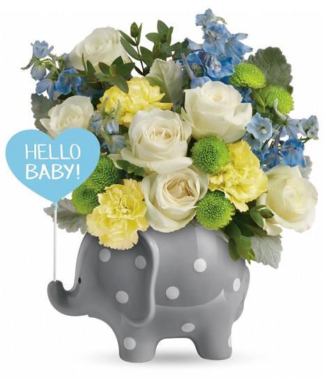 Polka-dotted elephant vase holding a blue and yellow flower bouquet.