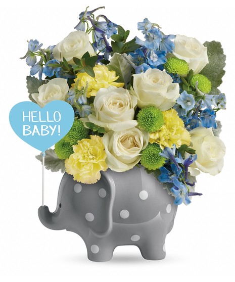 Polka-dotted elephant vase holding a blue and yellow flower bouquet.