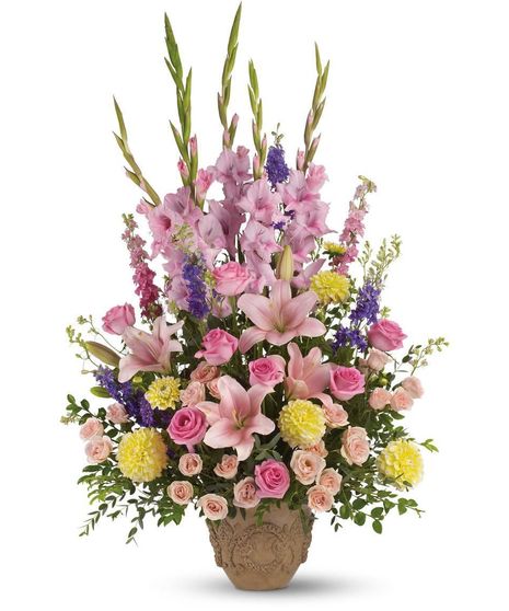 Sympathy arrangement of pink, yellow and lavender flowers in a memorial container.
