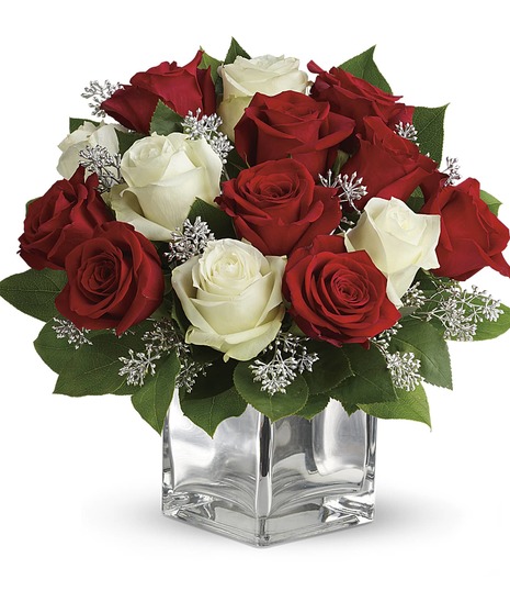 Red and white roses in a mirrored cube vase.