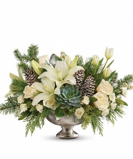 Mercury glass bowl of winter greenery and white blooms. 